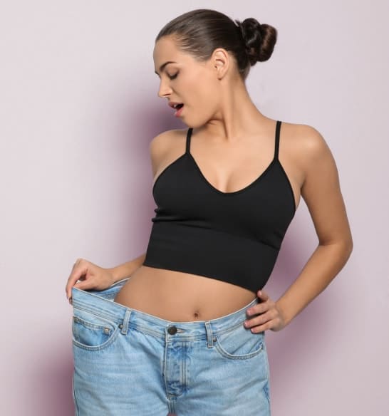 Woman in jeans that are now too big for her