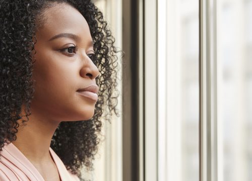 Woman experiencing vaginal dryness looking out the window