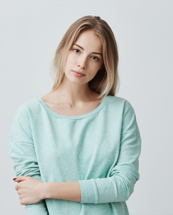 Young blonde woman wearing a green sweater
