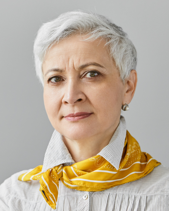 Older woman with short hair wearing a yellow scarf