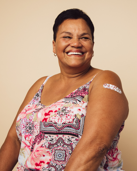 Smiling woman with a band-aid on her arm after receiving a vaccine