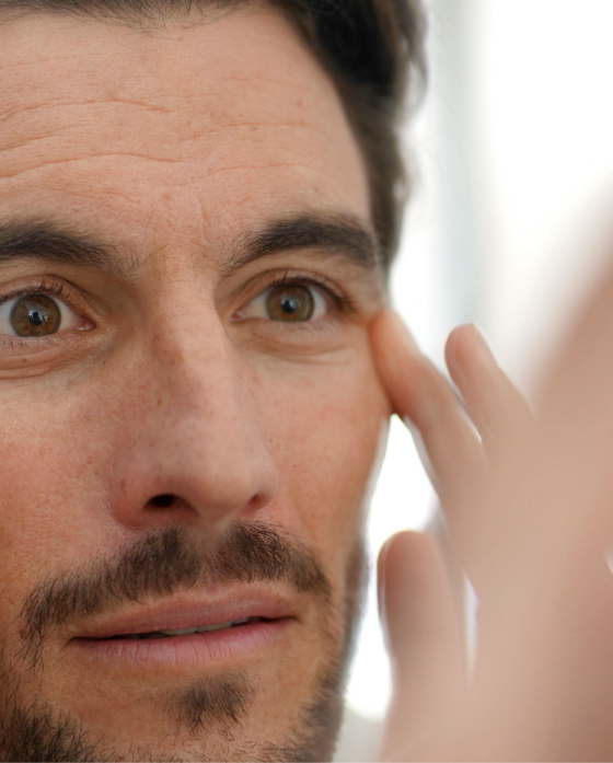 Man looking at his facial wrinkles in the mirror