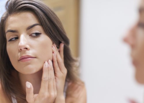 Woman checking for scars in the mirror